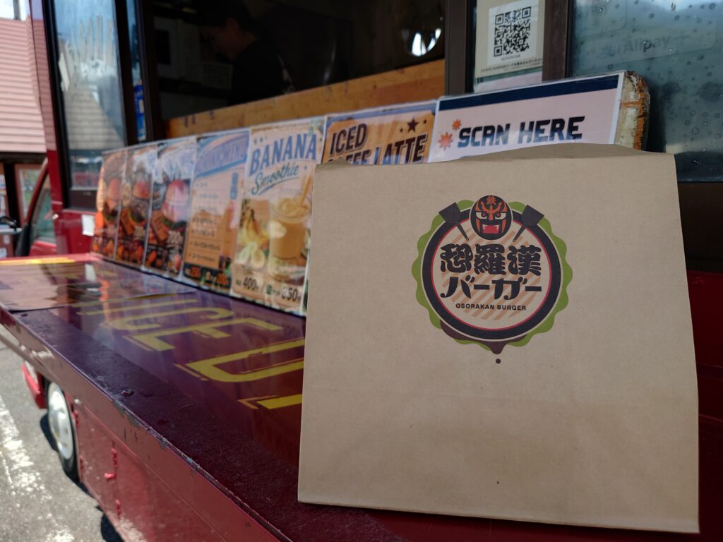 恐羅漢バーガーのロゴと移動販売車のカウンター