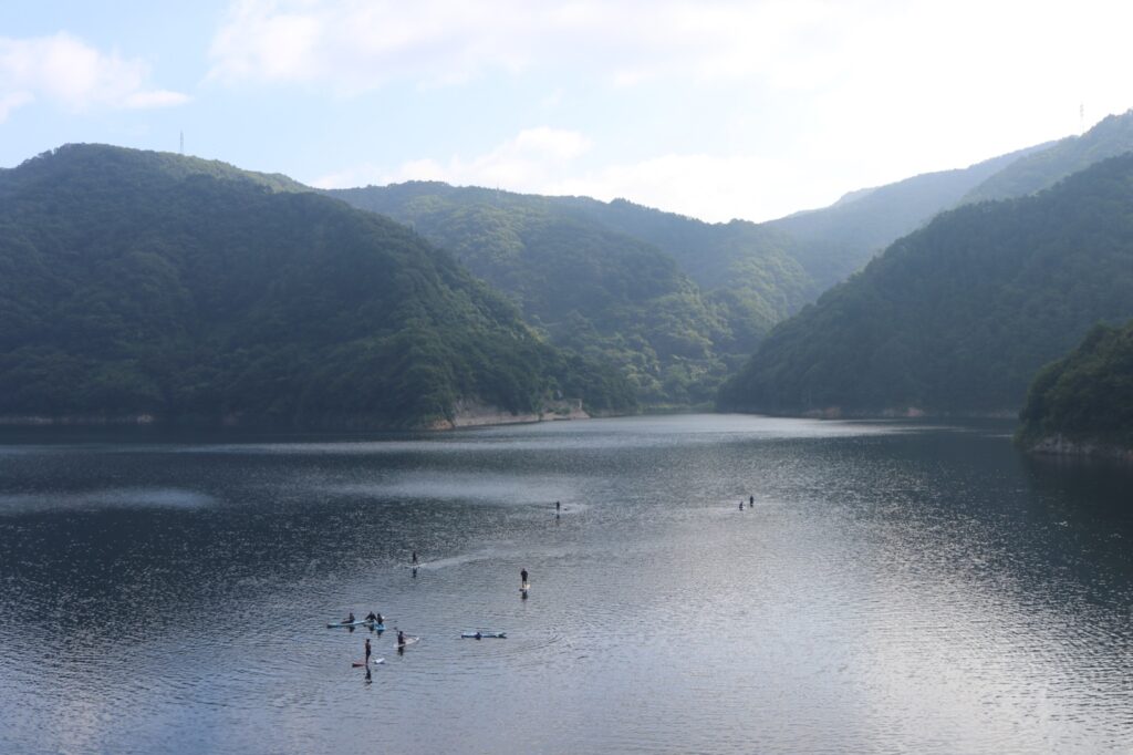 山々に囲まれた龍姫湖でSUPを楽しむ参加者