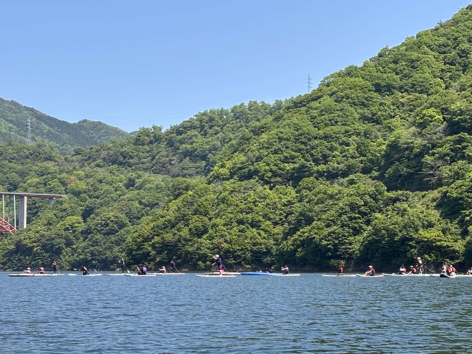 龍姫湖で並んで進むSUPとカヤックの参加者